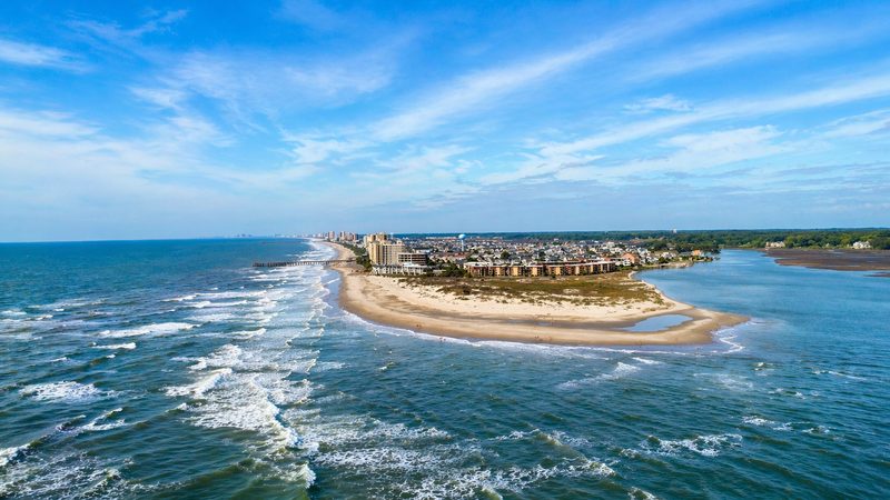 The Point at high tide — sandbar submerged, beach narrowed